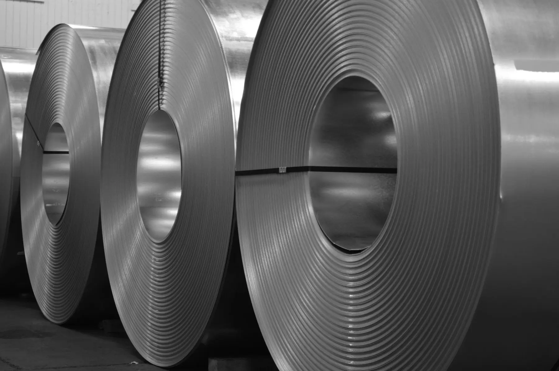 Row of bright cold-rolled steel coils on the warehouse floor at Alkar Steel and Processing