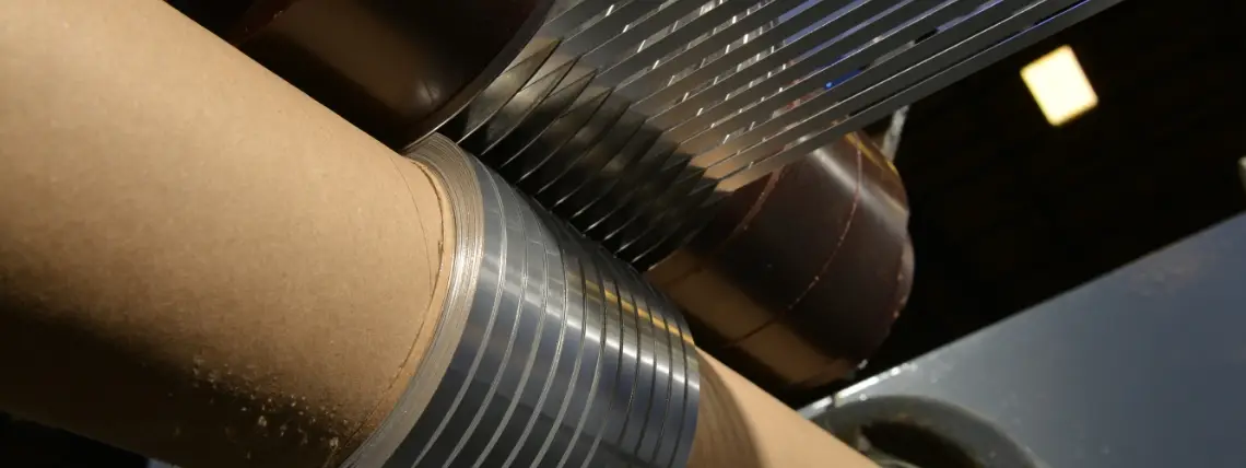 Slit aluminum foil strands rewinding onto cores at the end of an All Foils slitter