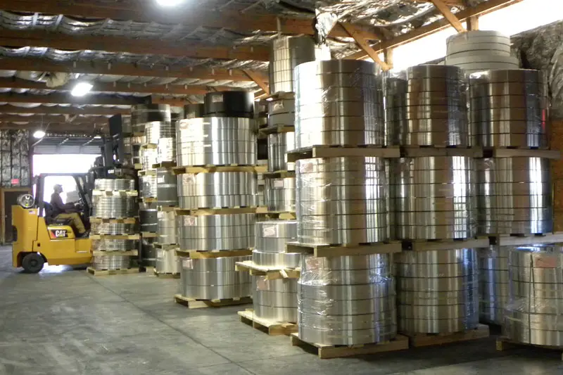 Stacks of slit aluminum coils on pallets in the Aluminum Coils, Inc. warehouse