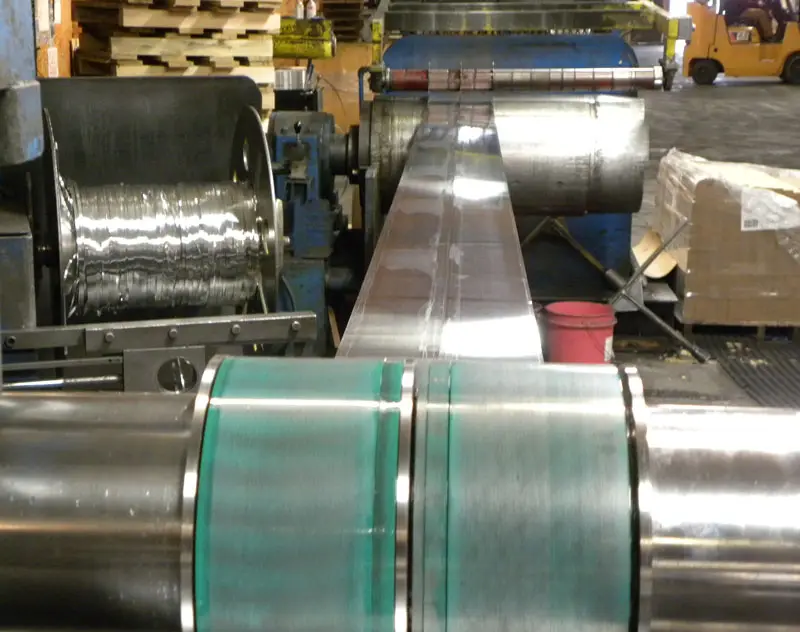 Aluminum strip being slit and rewound on an Aluminum Coils, Inc. slitting line