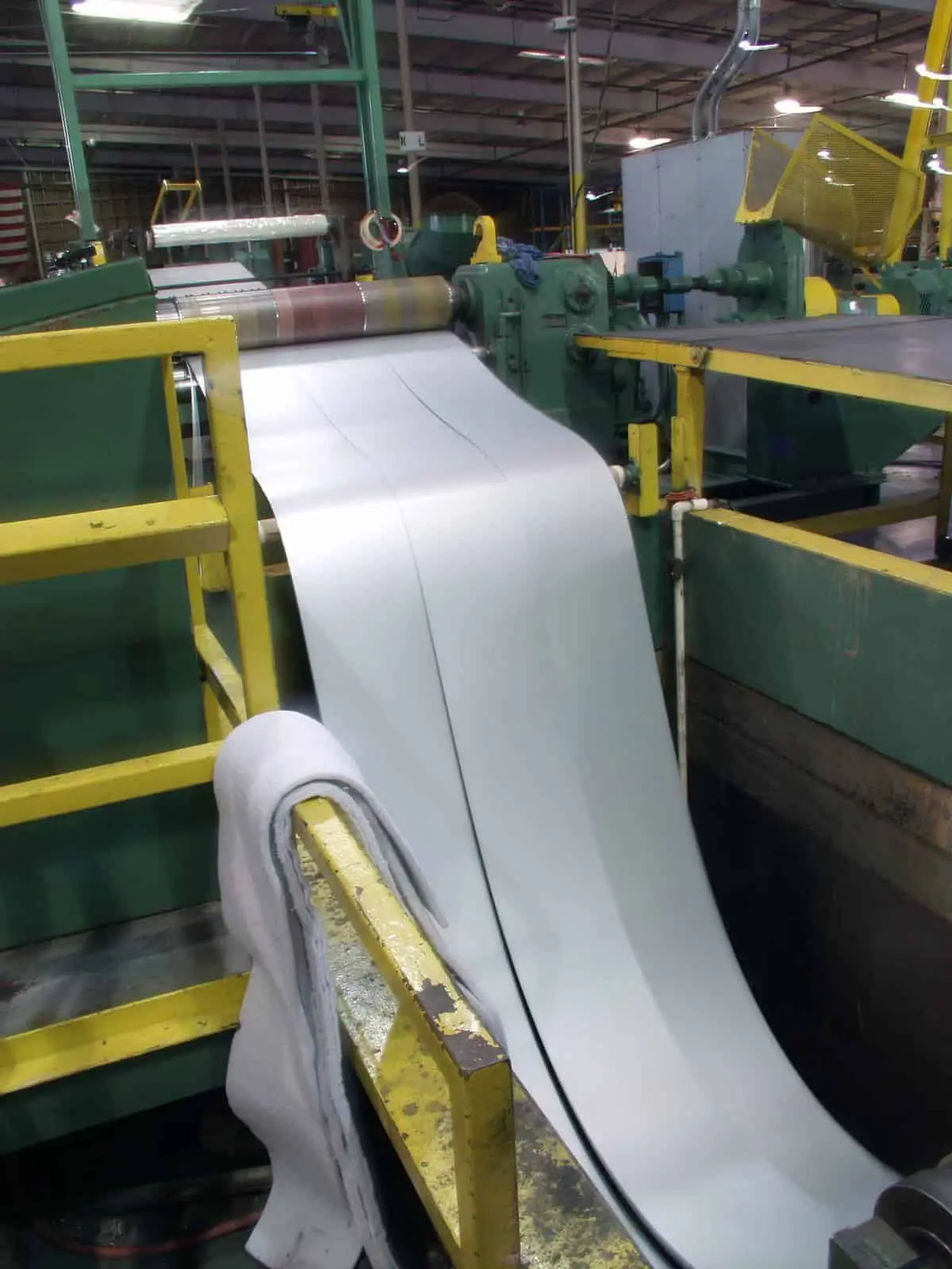 Coated metal strip feeding through an American Douglas Metals slitting line