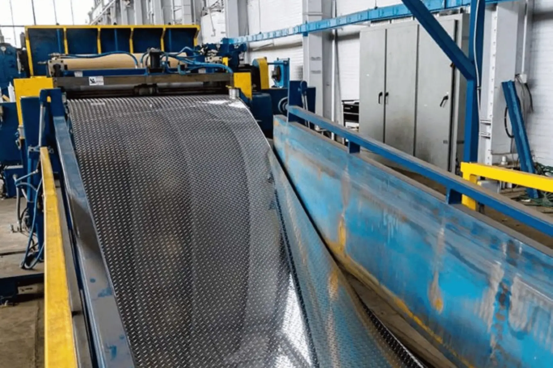 Metal sheet running through processing equipment at Amerinox Processing