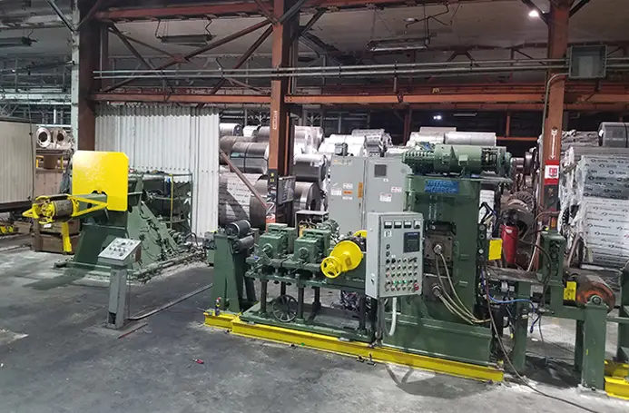 Coil processing line with uncoiler and controls inside an Andes Coil Processors plant
