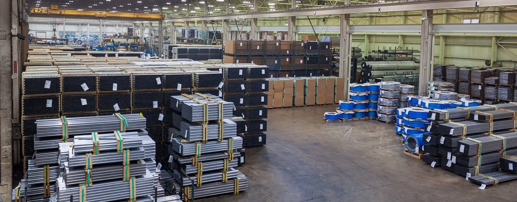 Warehouse floor stacked with bundled stainless and aluminized sheet and tubing at Atlas Steel