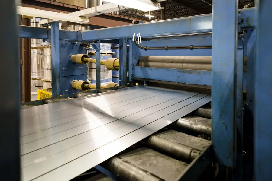 Forklift working cantilever racks stocked with metal sheet bundles in the warehouse