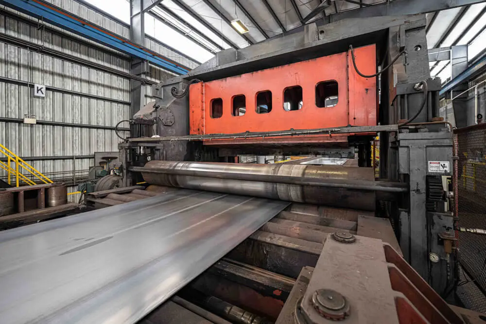 Wide steel sheet running through the leveler on Beshert's temper pass and cut-to-length line