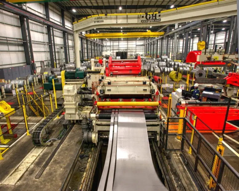 Blue Springs Metals slitting line running steel strip under an overhead crane bay