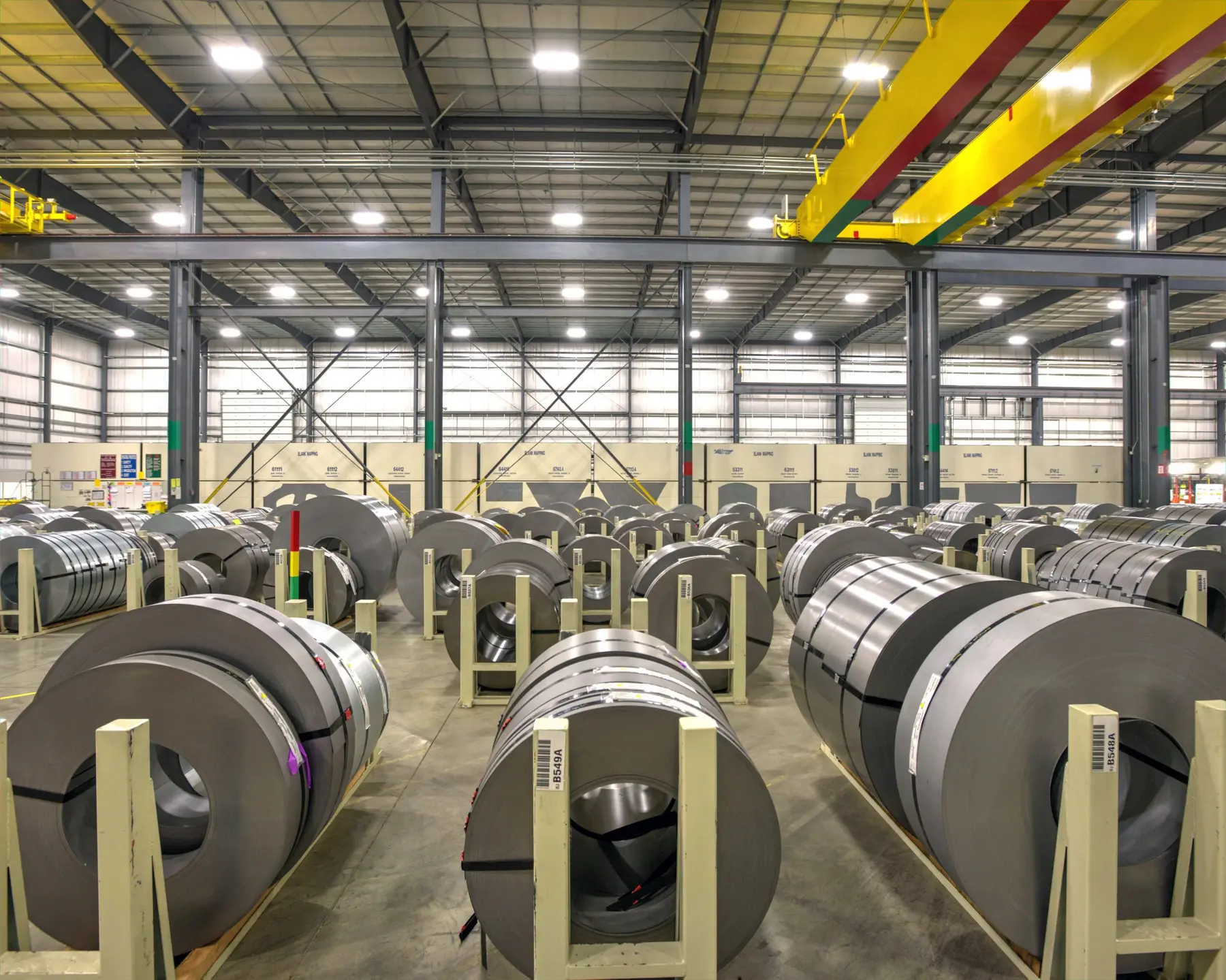 Rows of steel coils on cradles in the Blue Springs Metals climate-controlled warehouse