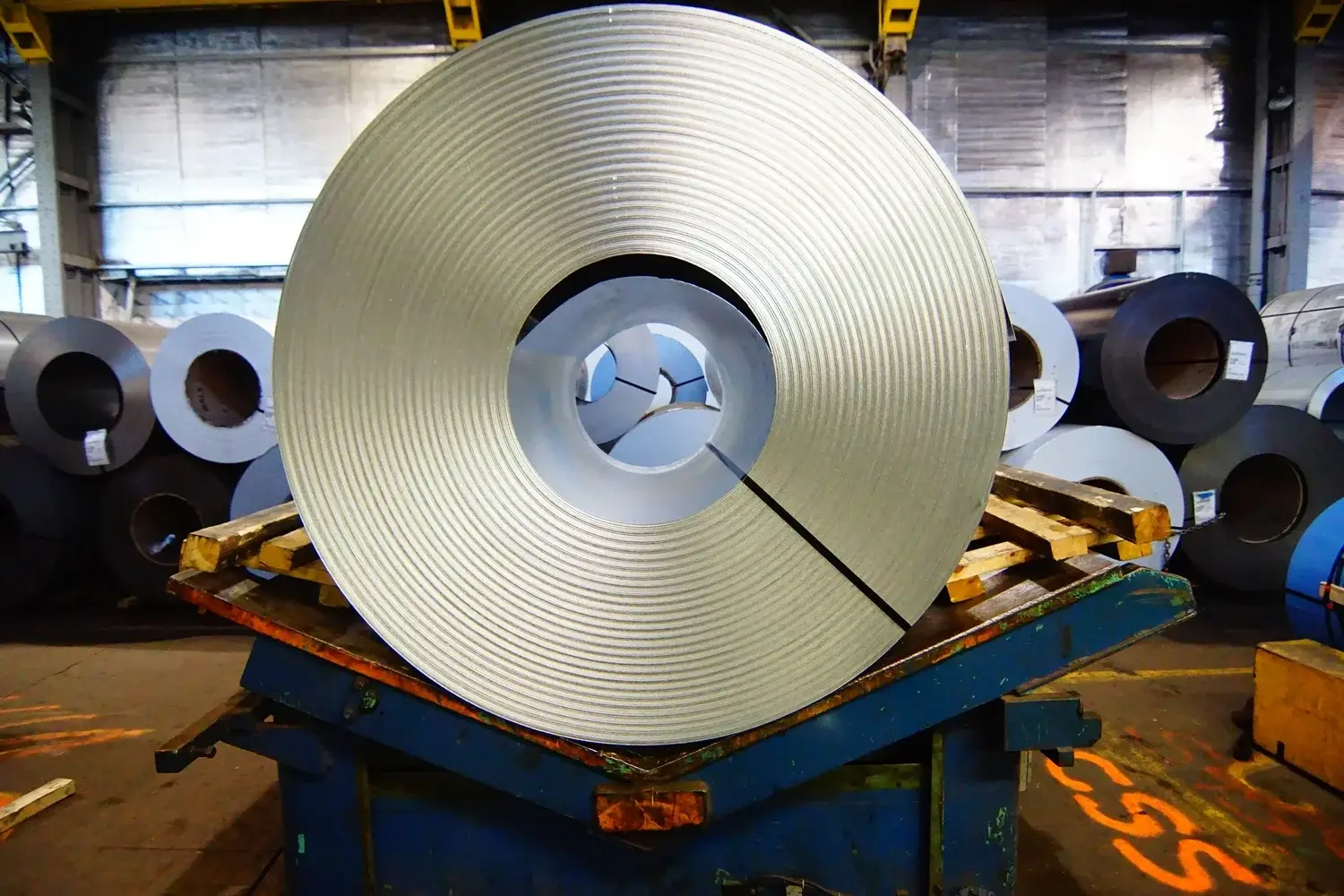 A packaged cold-rolled steel coil on a coil saddle with coil inventory behind it