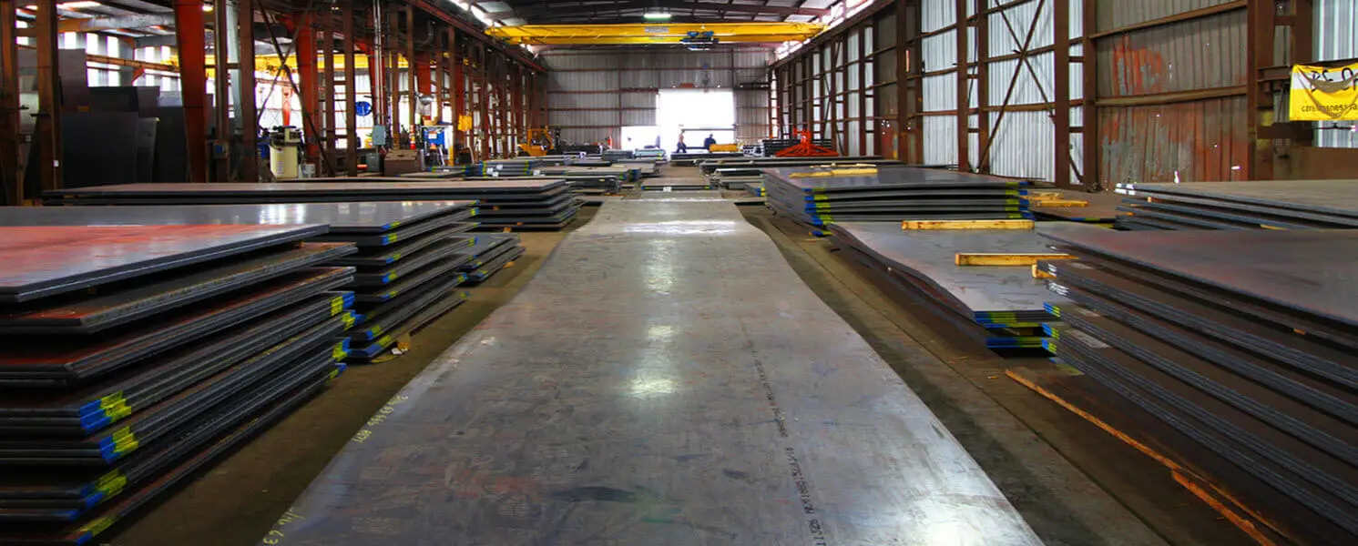 Stacks of weathering steel plate along the aisle of Central Steel Service's indoor warehouse