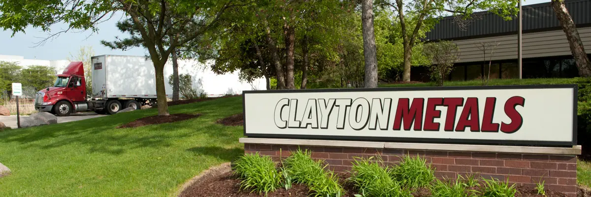 Clayton Metals sign outside the Wood Dale facility with a truck at the dock
