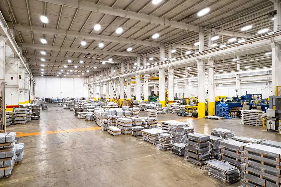 Wide interior view of the Coilplus Alabama plant with stacked steel sheet bundles