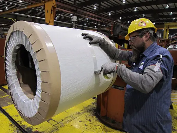 Slit stainless coil being wrapped and edge-protected for shipment on the packaging floor
