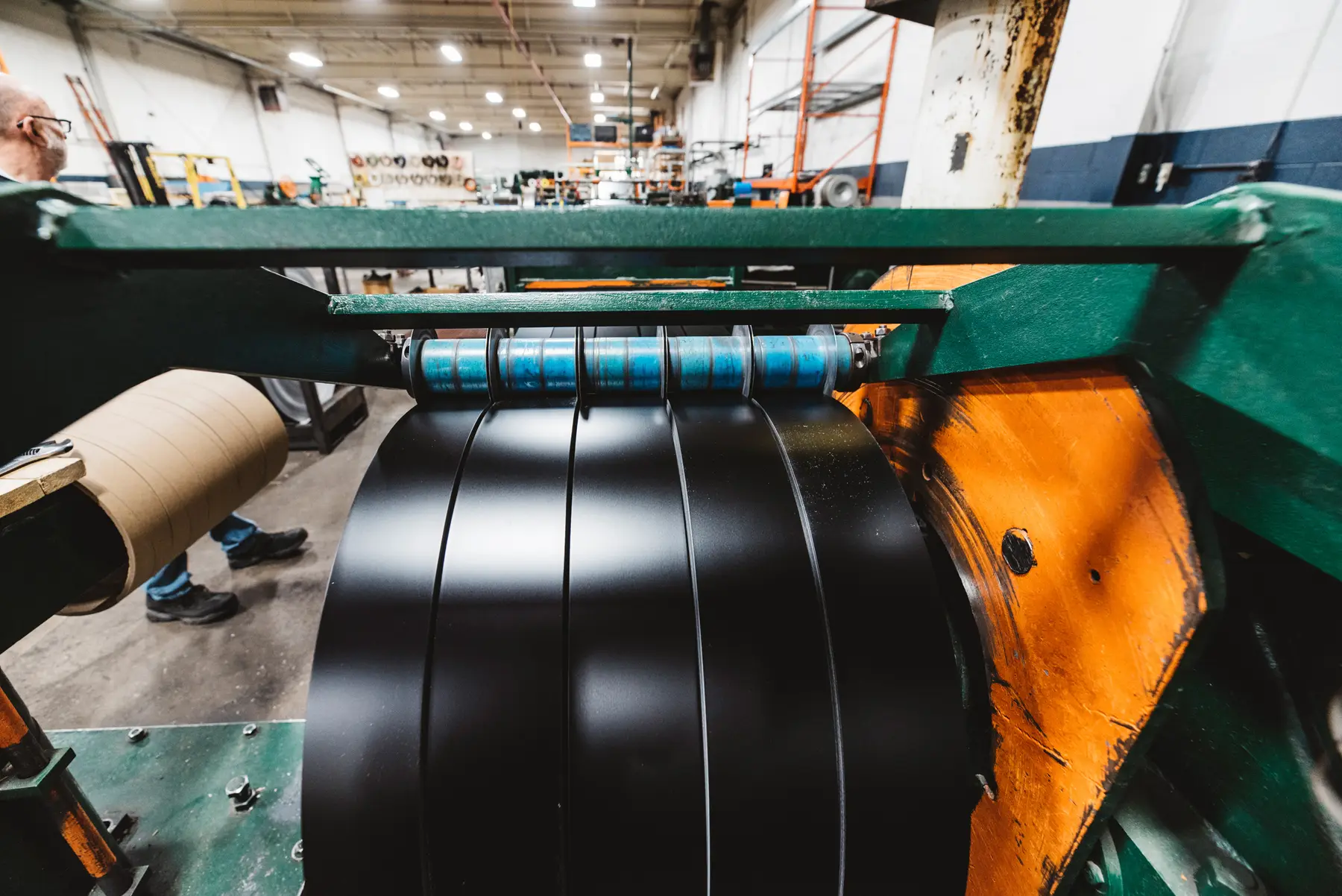Stainless steel strip being slit into narrow coils on a slitting line at Elite Stainless Steel