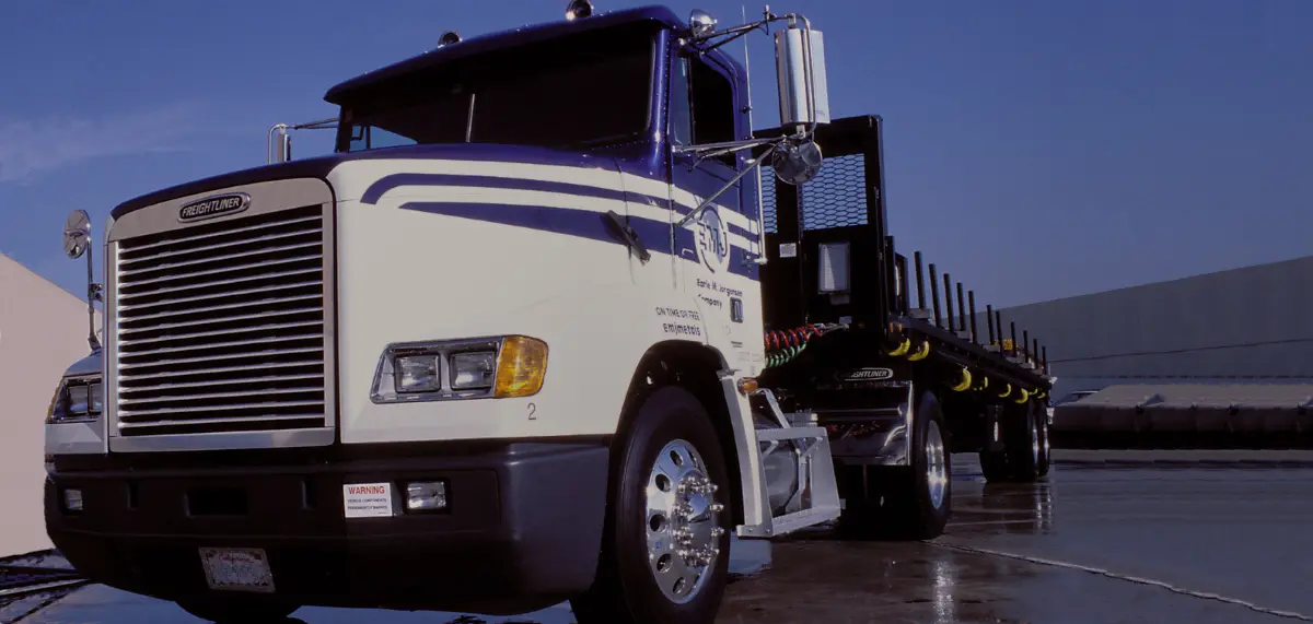 EMJ flatbed delivery truck at a service center loading area