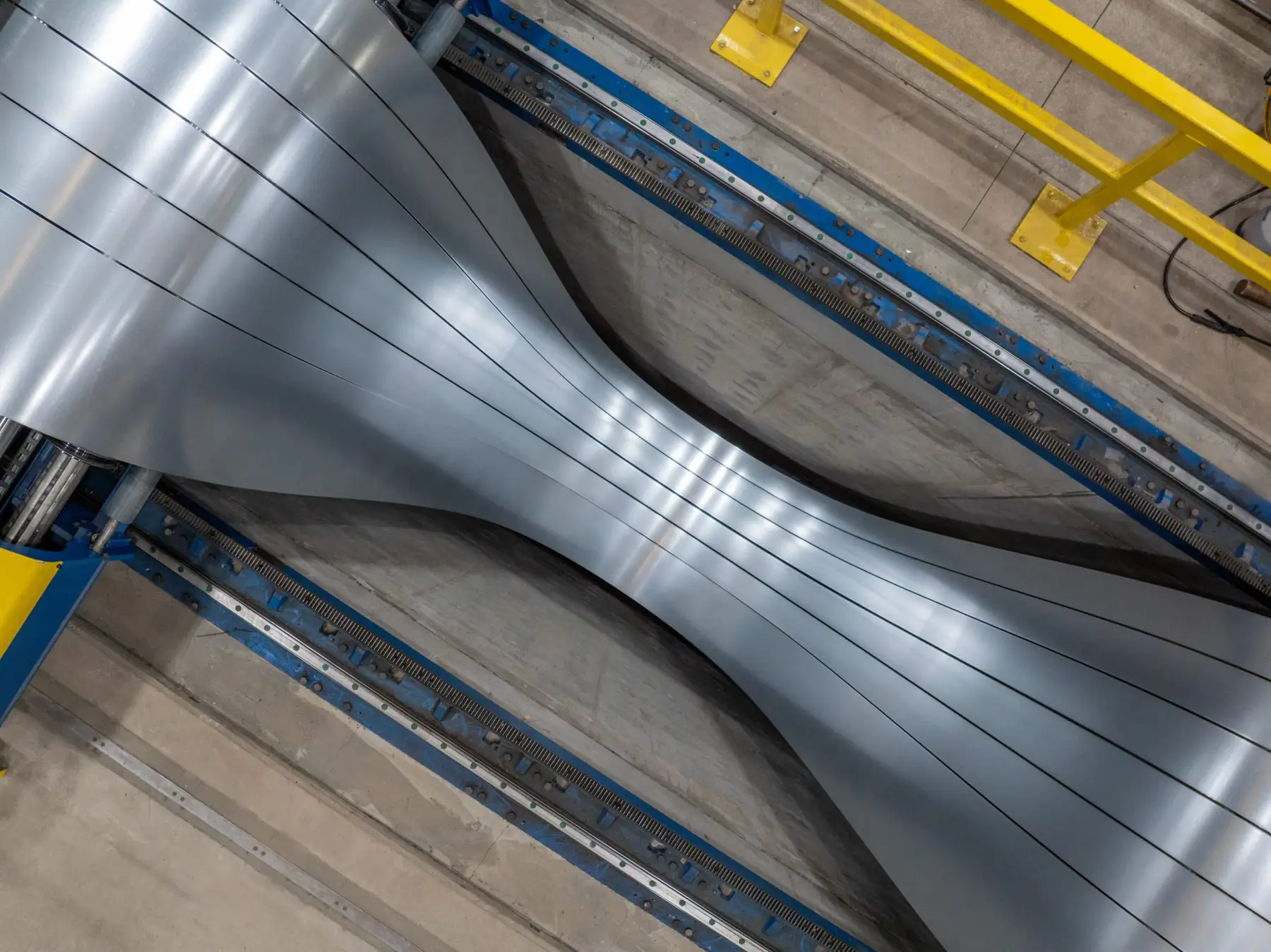 Slit steel strands looping through the pit of a slitting line
