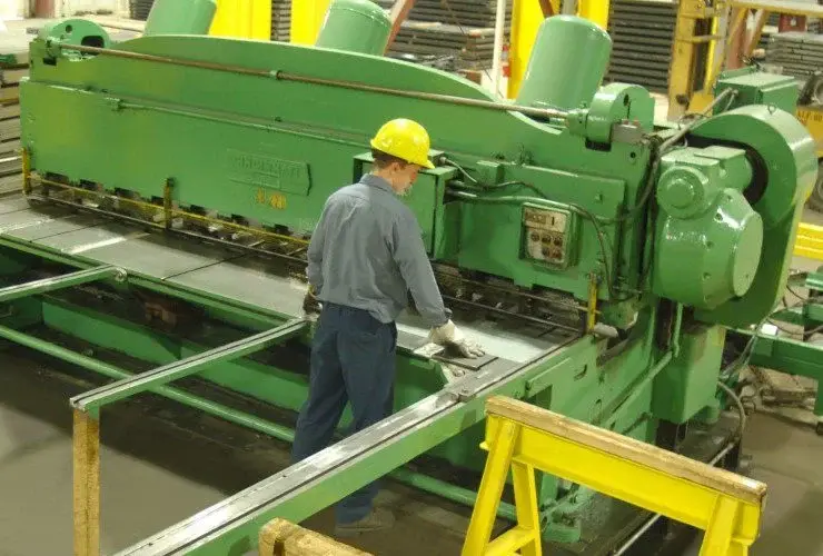 Operator running a shear line cutting steel sheet to size