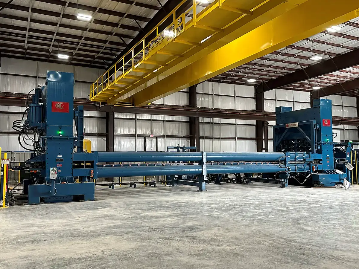 Stretcher leveler line beneath an overhead crane in a Friedman flat-roll processing plant