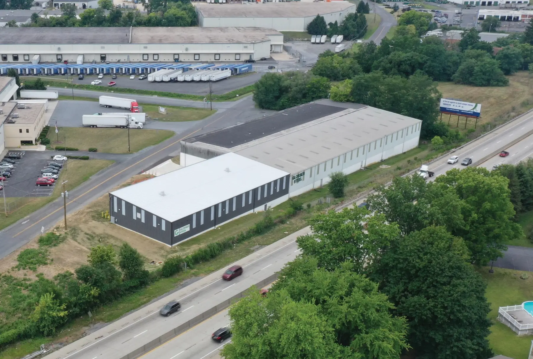 Aerial view of a Glosser Steel service center warehouse beside a highway