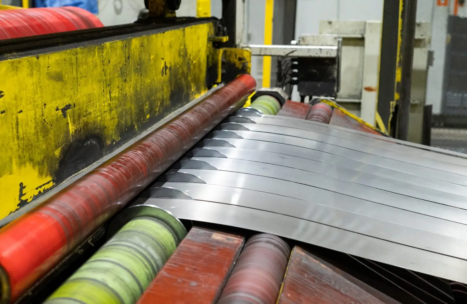 Close view of steel strip passing through slitter rolls on a processing line