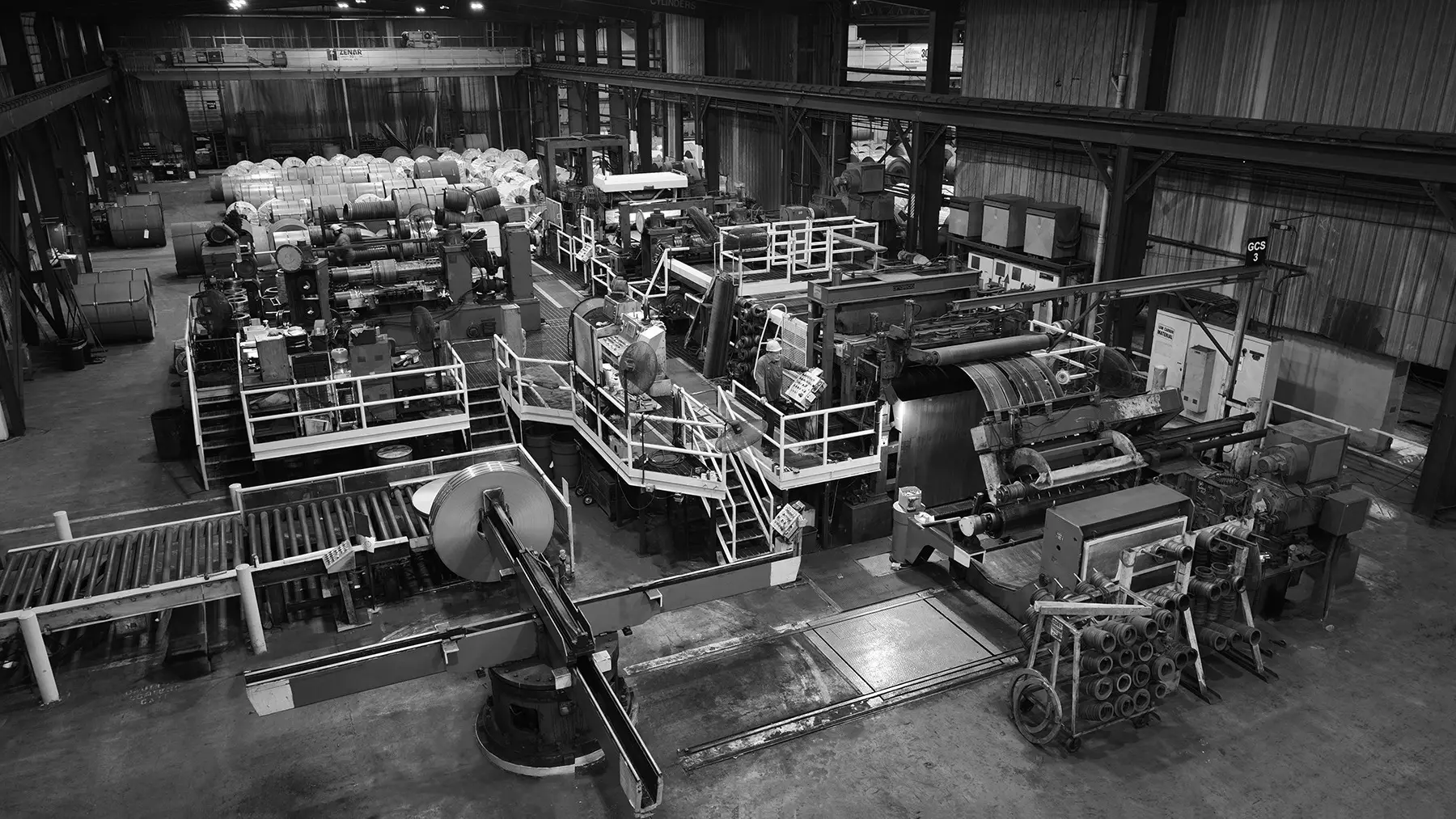 Black-and-white overhead view of a slitting line with coils on the plant floor