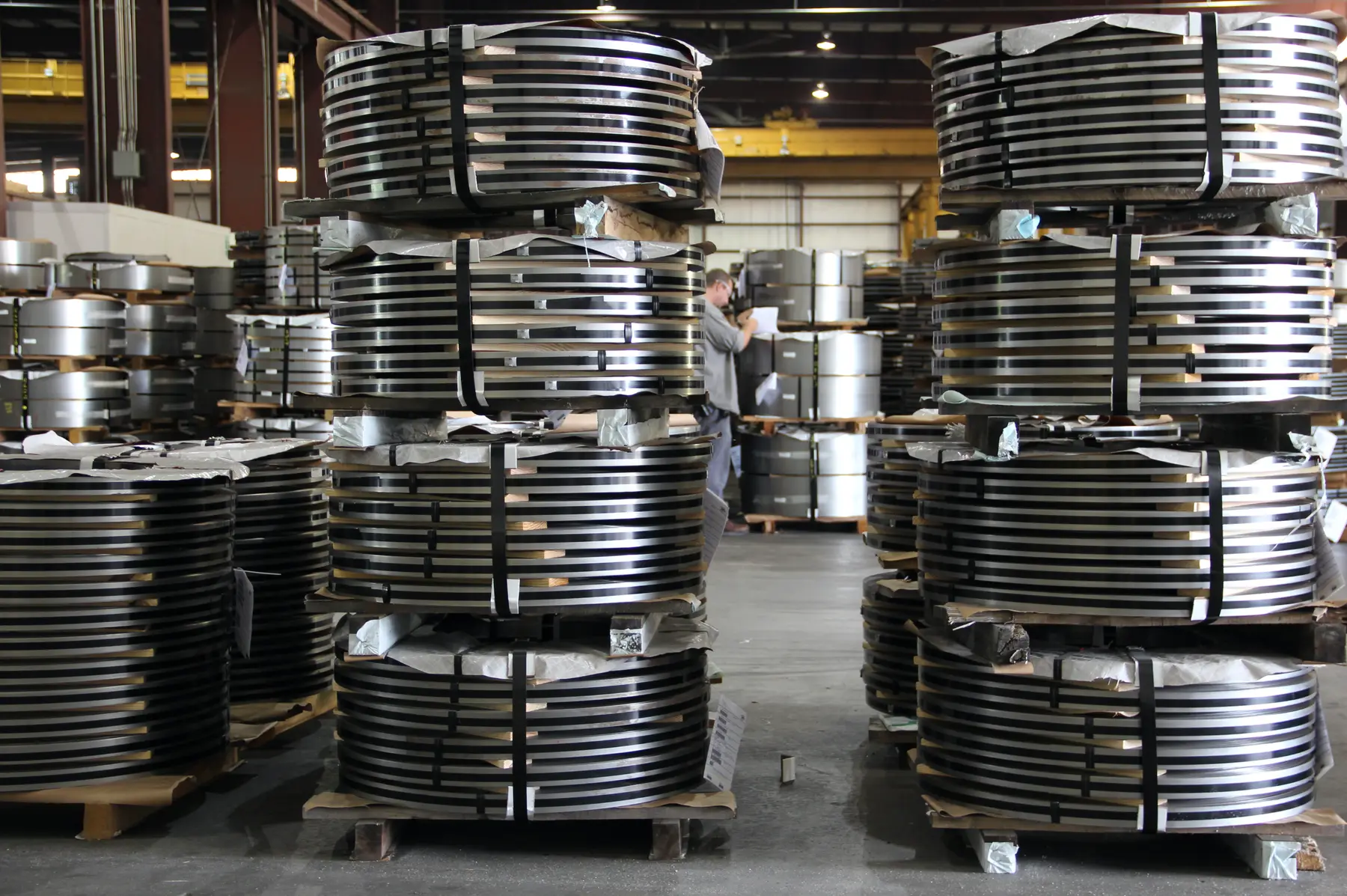 Stacks of slit steel coils on pallets in JM Steel's warehouse