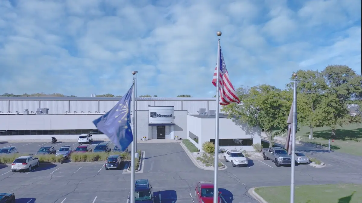 Aerial front view of Kenwal Steel headquarters building with flags and parking lot