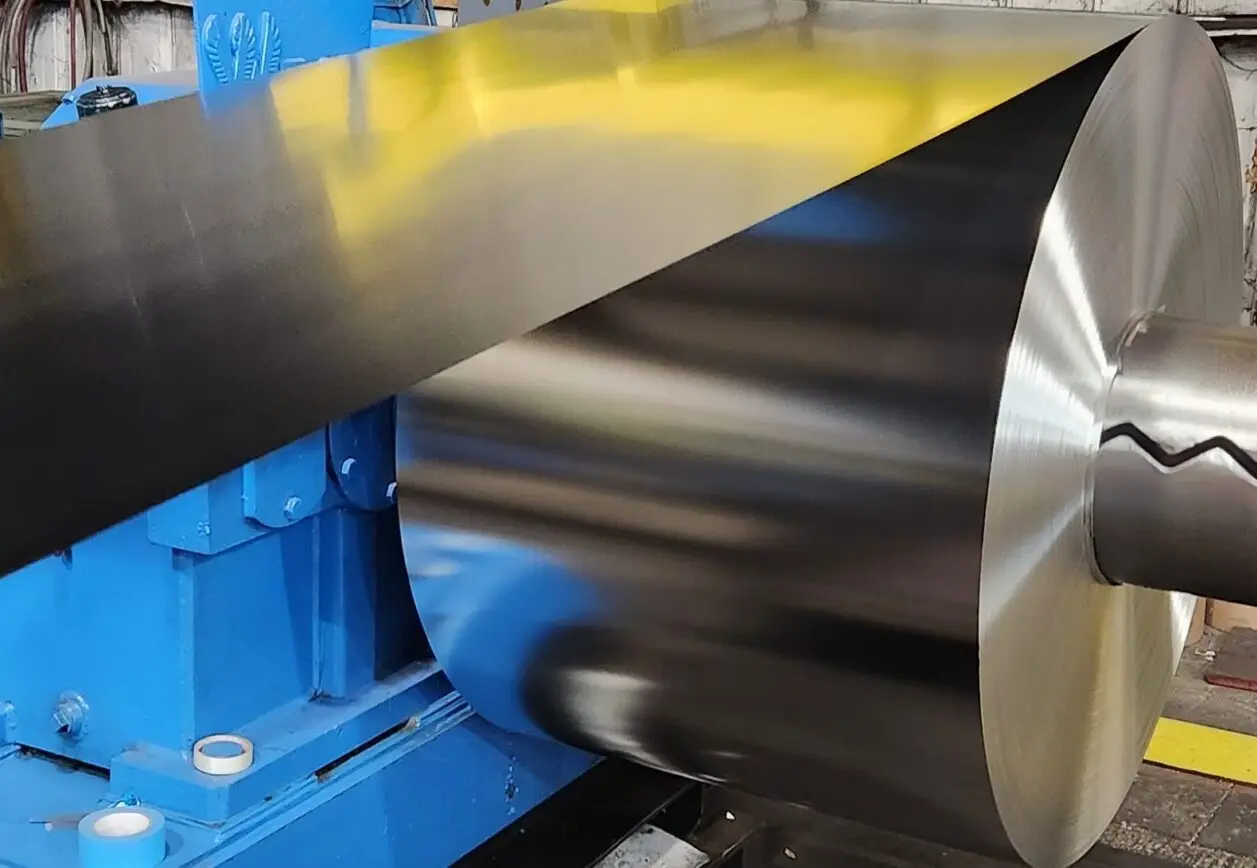 Light-gauge steel strip unwinding from a coil on the Paxson uncoiler at Lakeside Metals