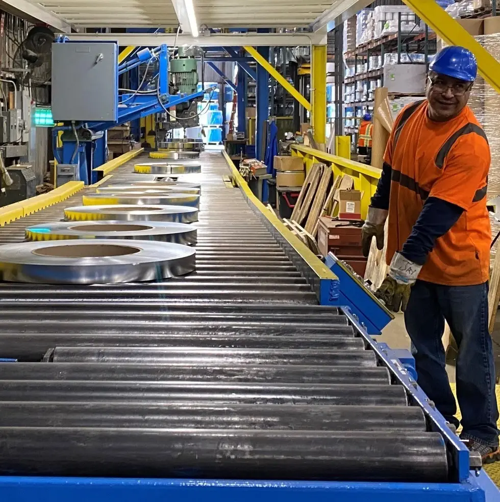 Slit coils moving along the roller conveyor of a Lakeside Metals packaging line