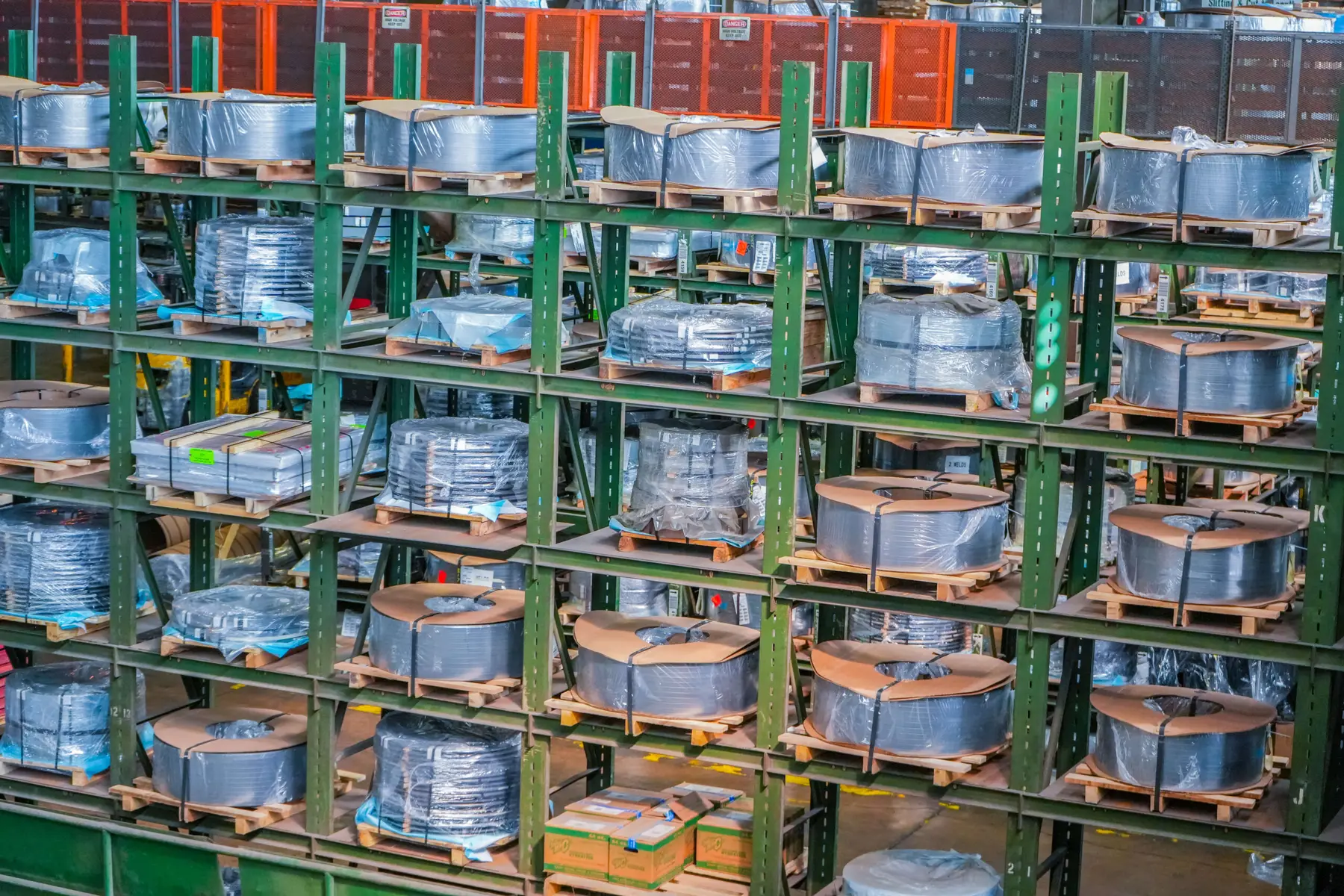 Green storage racks filled with packaged slit steel coils in the warehouse