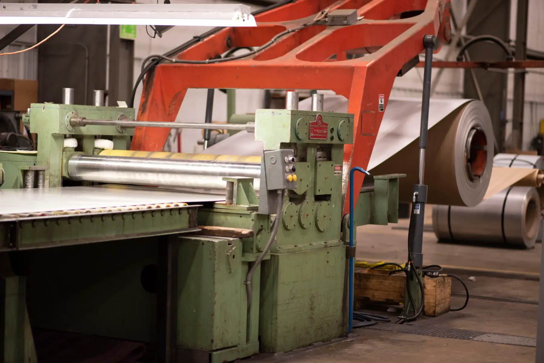 Coil feeding a green processing line at LaPorte Custom Metal Processing, with master coils staged behind