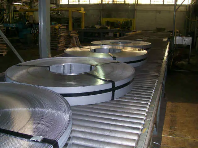 Banded slit steel coils moving down a roller conveyor in the Liberty Steel Processing plant