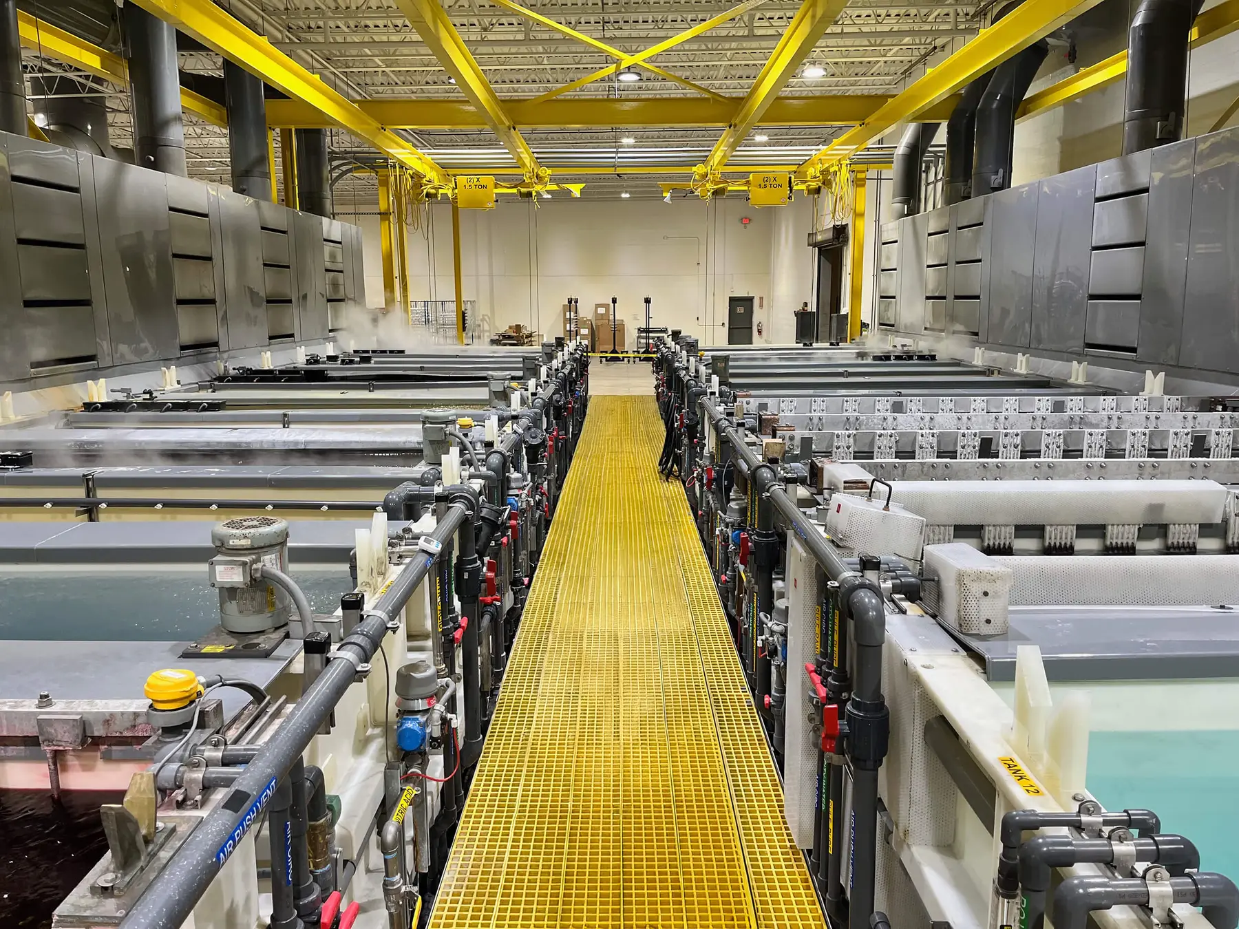 Anodizing tank line with a yellow grated center walkway inside Lorin Industries' Muskegon plant