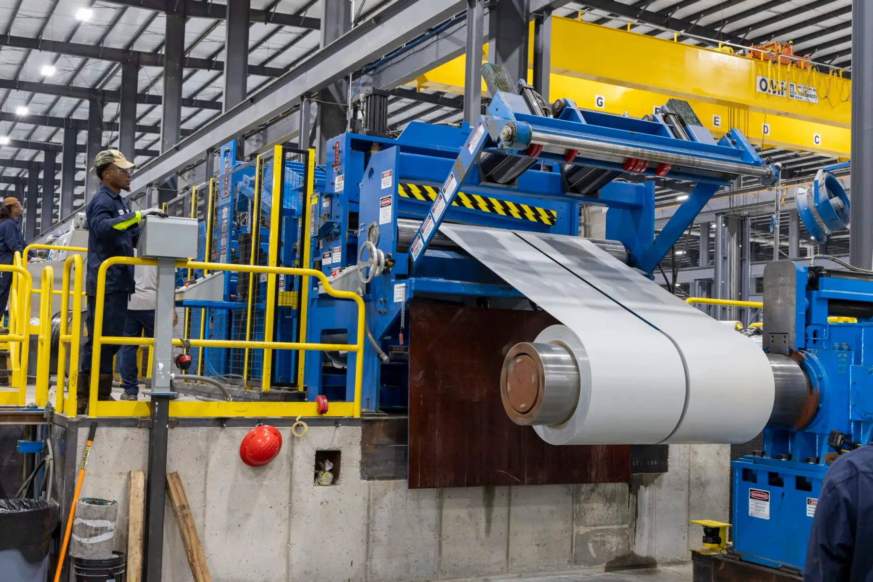 Steel coil feeding into a processing line at Majestic Steel's Arkansas service center