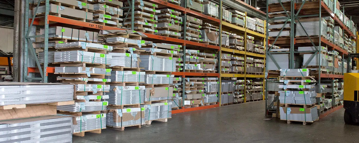 Tall racks of aluminum sheet and plate inventory in the Mandel Metals warehouse