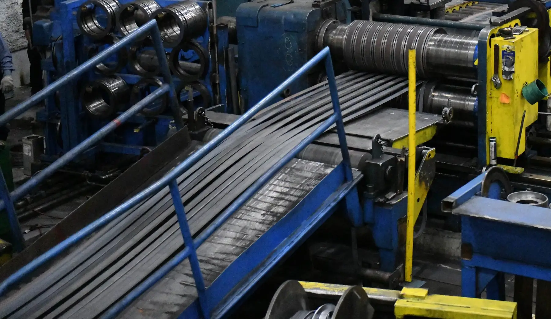 Narrow steel strands leaving the slitter heads on an MD Metals heavy-gauge slitting line