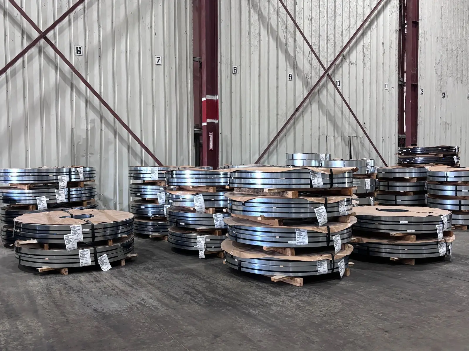 Stacks of banded slit steel coils on skids inside a Metal Master warehouse