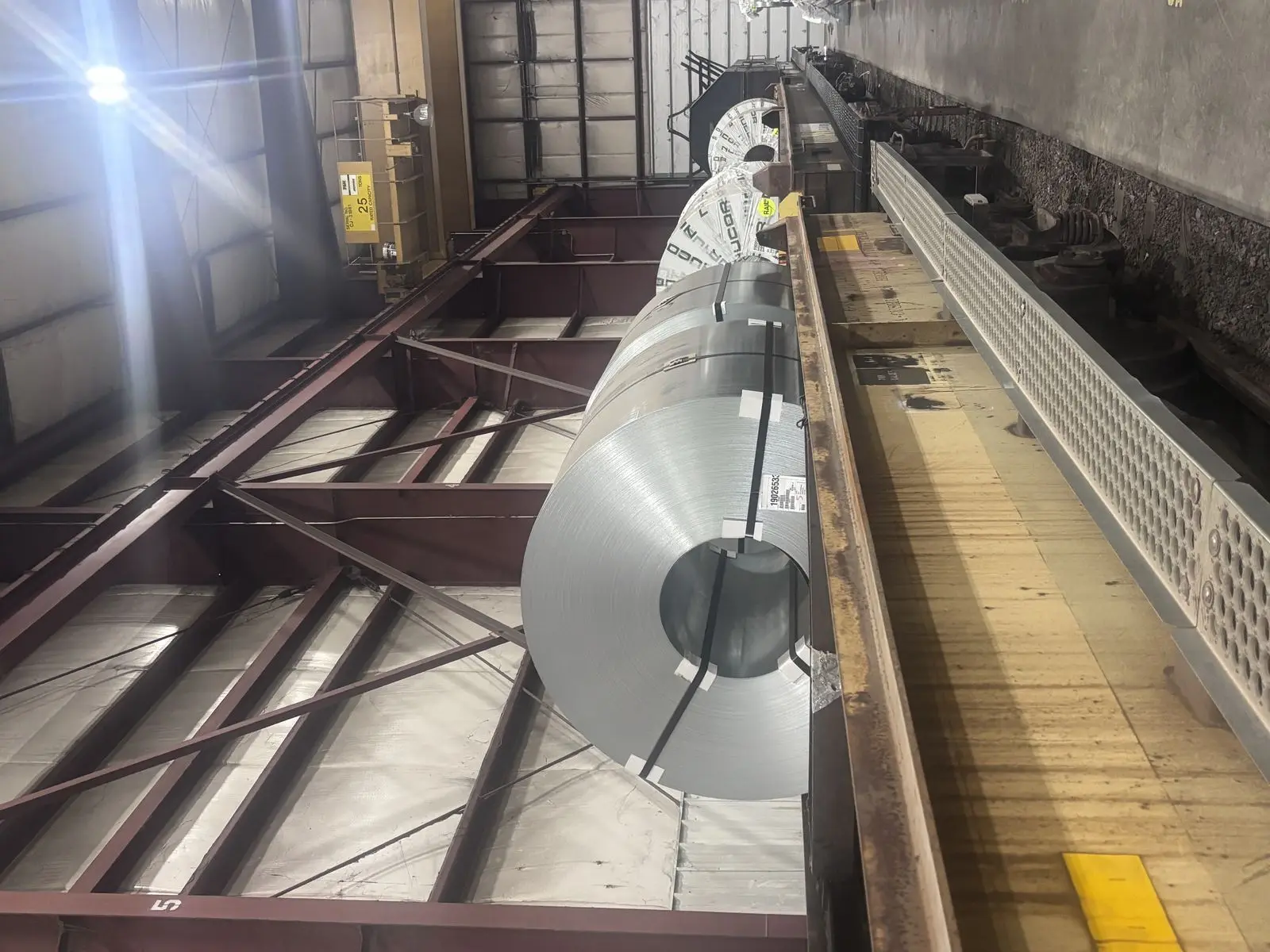 Galvanized steel coil being transferred along a rail-served bay at a Metal Master facility