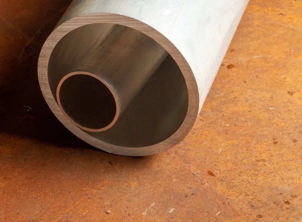 Aluminum round tube sections resting on a steel work surface