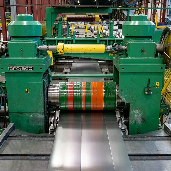 Steel strip running through the green Pro-Eco heavy-gauge slitter at Miami Valley Steel in Piqua