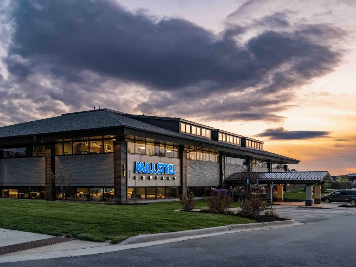 Mill Steel Company headquarters building at dusk with its illuminated sign