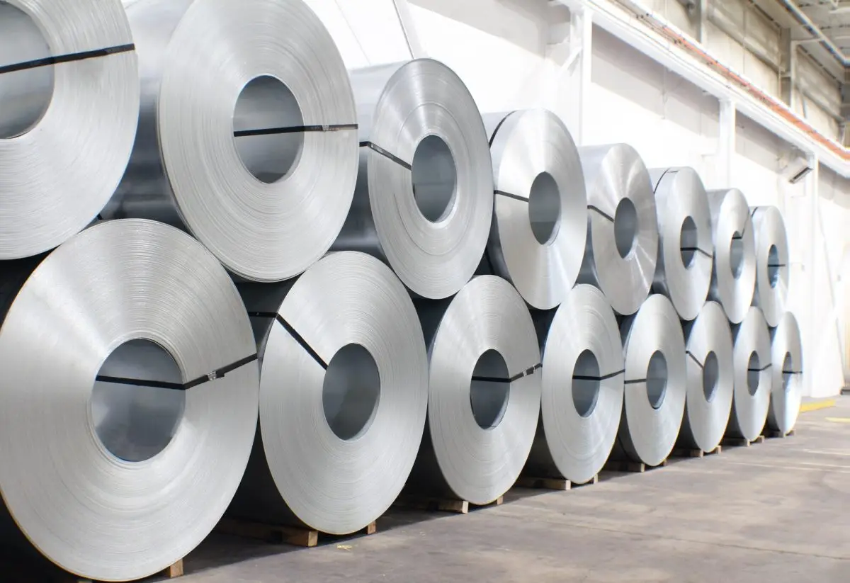 Long rows of bright galvanized steel coils stacked two high in a Mill Steel warehouse