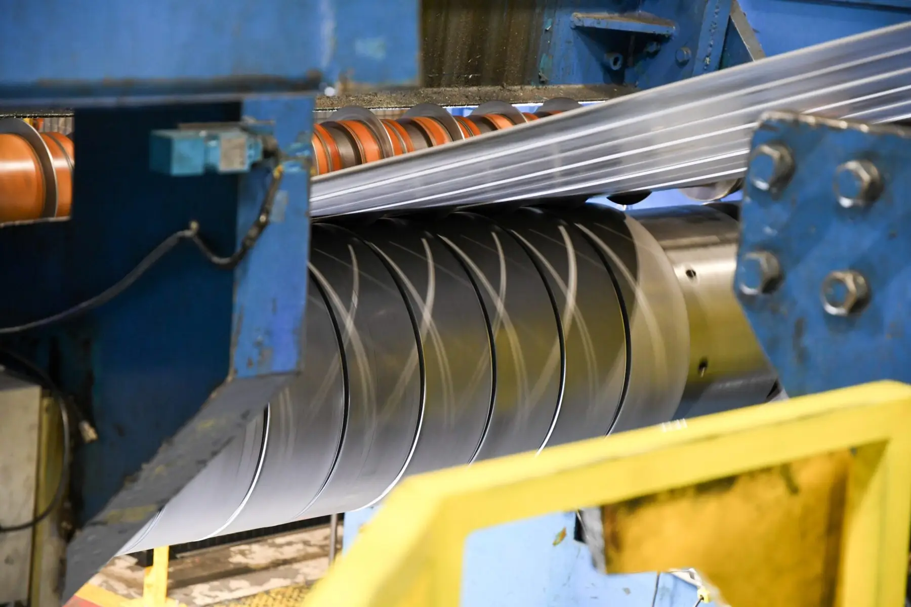 Steel strip passing through the slitter knives on a MISA Metal Processing slitting line