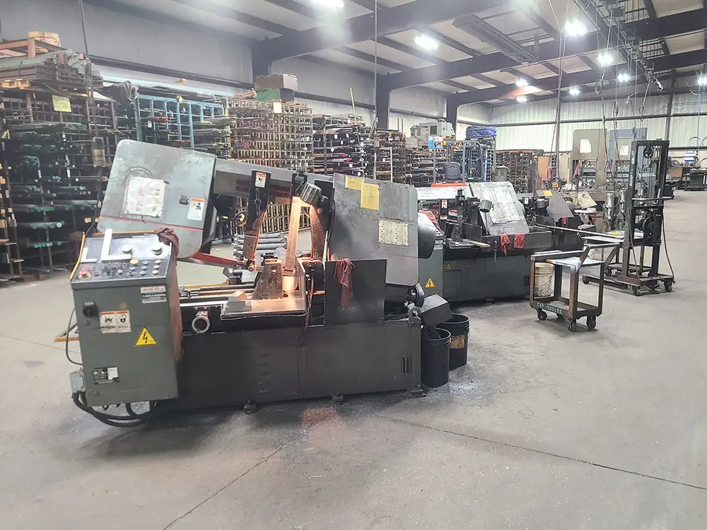 Automatic production band saws cutting bar stock on the NESSteel shop floor in Tolland