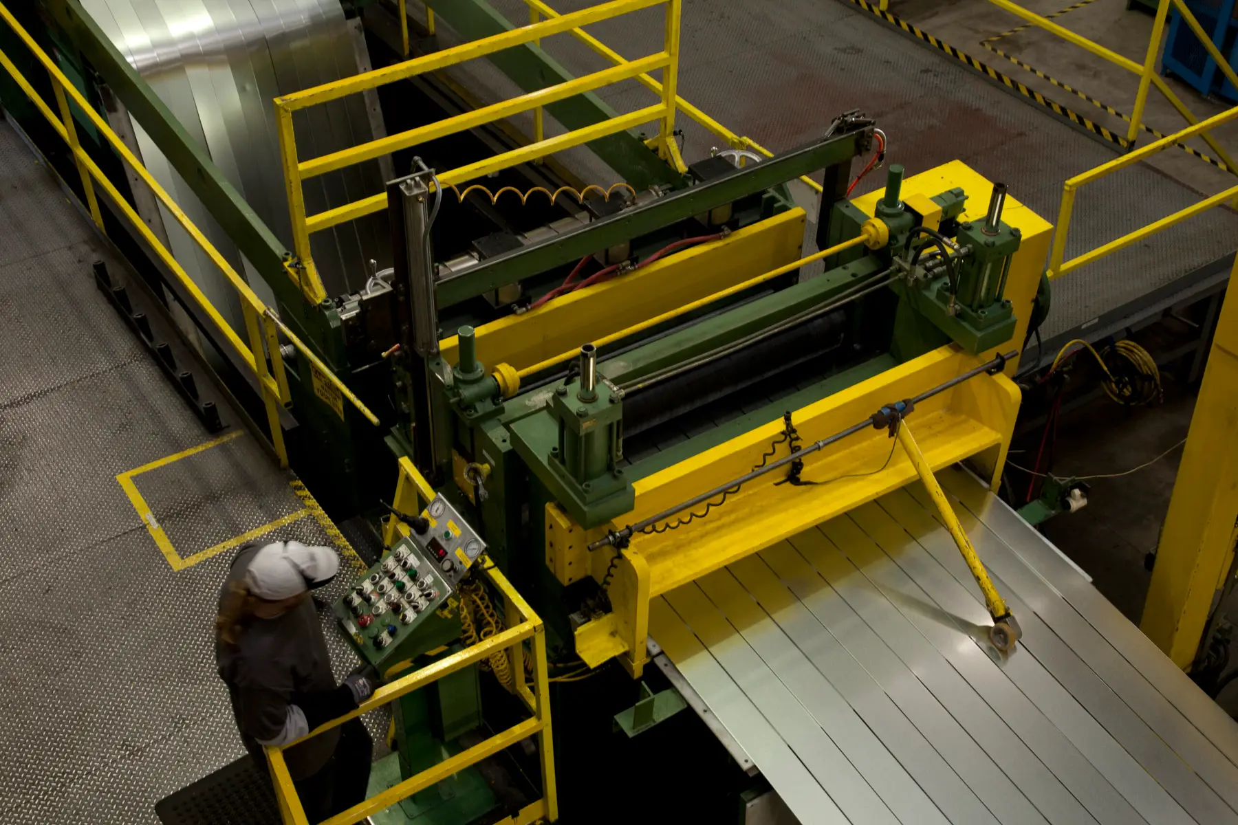 Overhead view of a coil slitting line with slit steel strip leaving the slitter head