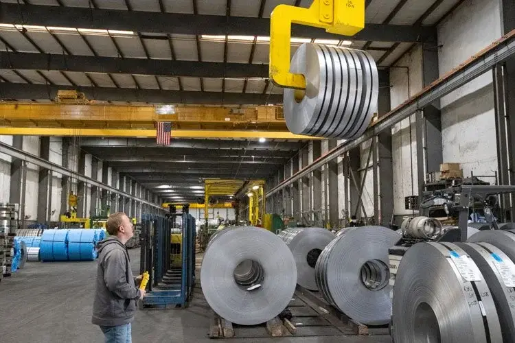 Overhead crane lifting a slit coil above rows of coils in Ohio-Kentucky Steel's Franklin warehouse