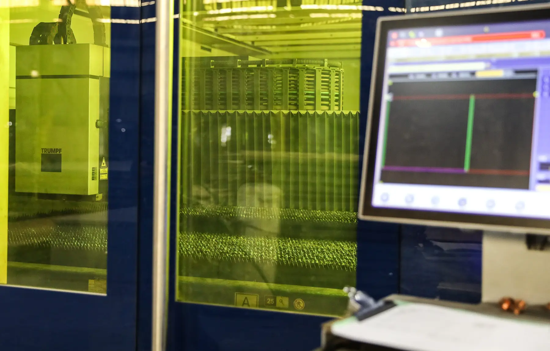 Enclosed fiber laser cutting machine with its control screen at an O'Neal Steel service center