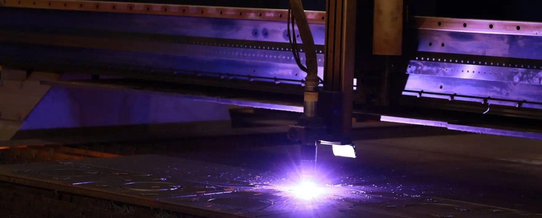 CNC plasma torch cutting steel plate on a burning table at O'Neal Steel in Birmingham