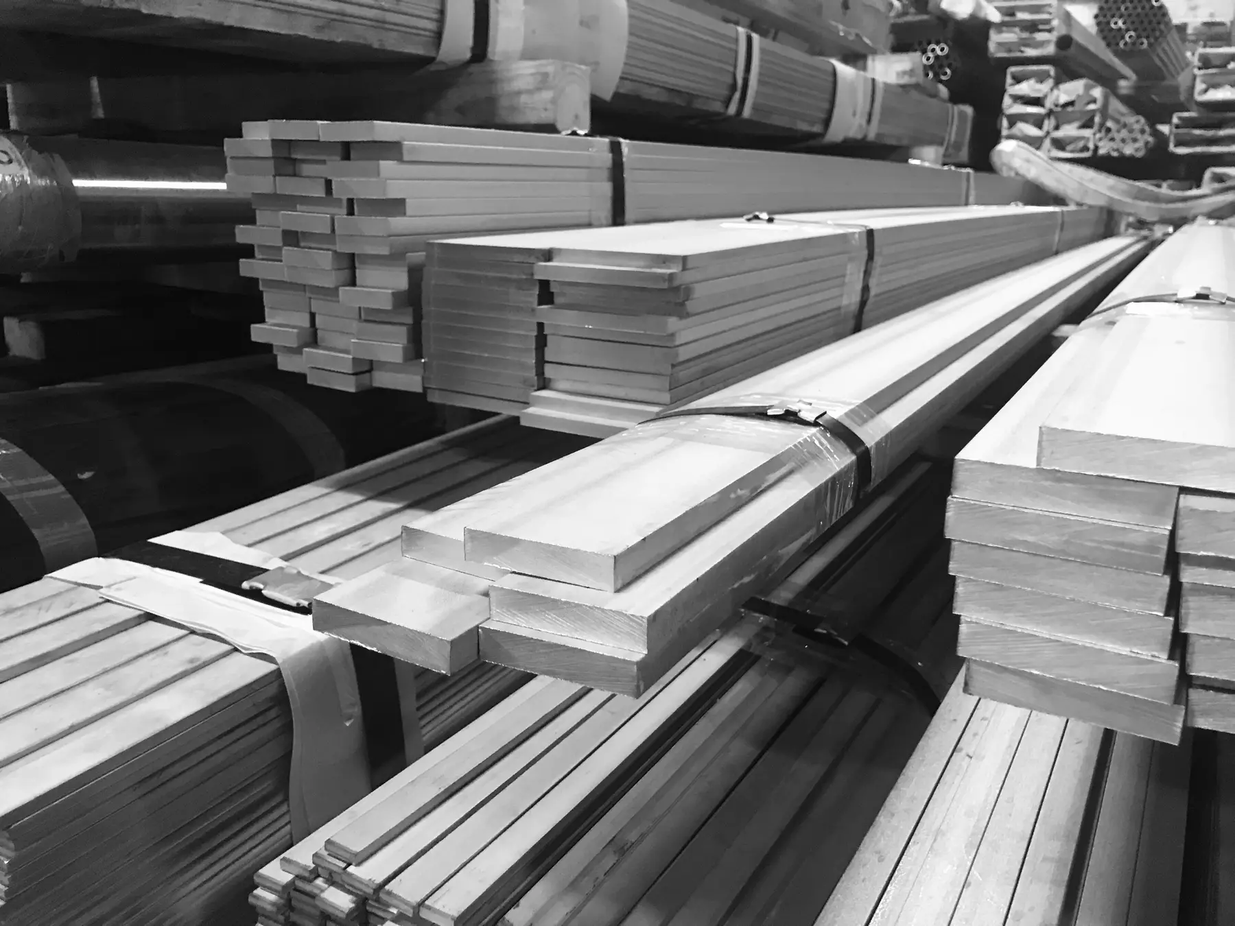 Bundles of stainless steel flat bar stacked in a warehouse rack