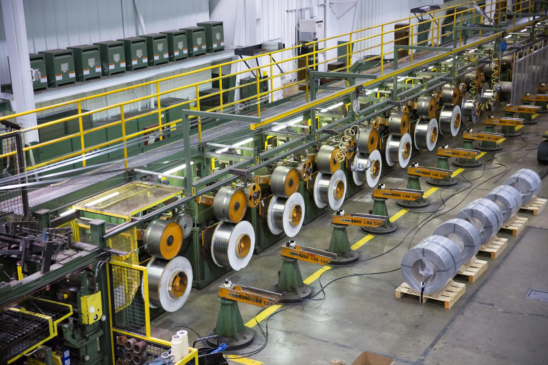 Oscillate slitting line with a row of wound coils on rewind stands